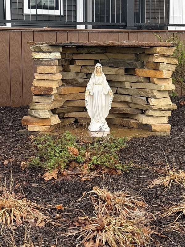 Stacked natural stone grotto with a white Mary statue