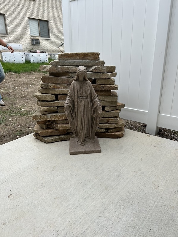 Natural stone grotto with a Mary statue under construction